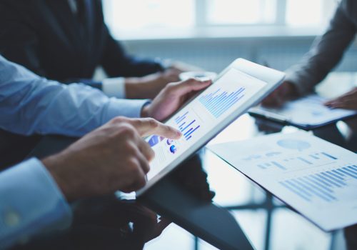 Analyzing electronic document Image of businessperson pointing at document in touchpad at meeting